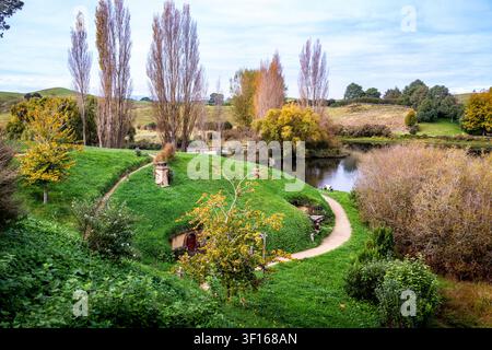 Ein malerischer Blick auf das Hobbiton-Filmset in Matamata, Neuseeland, das ein charmantes Hobbit-Haus zeigt, das in üppigen grünen Hügeln eingebettet ist. Stockfoto
