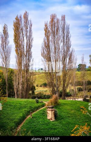 Ein malerischer Blick auf das Hobbiton-Filmset in Matamata, Neuseeland, das ein charmantes Hobbit-Haus zeigt, das in üppigen grünen Hügeln eingebettet ist. Stockfoto