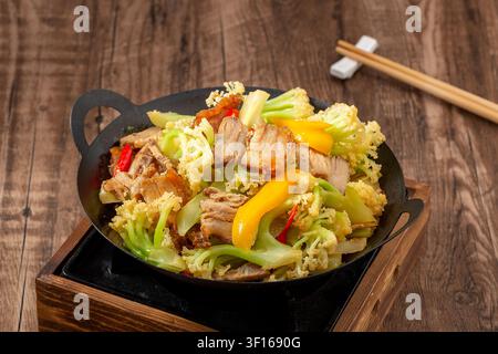 Gebratene Blumenkohl-Scheiben mit knusprigem Schweinebauch und Chilischoten Stockfoto