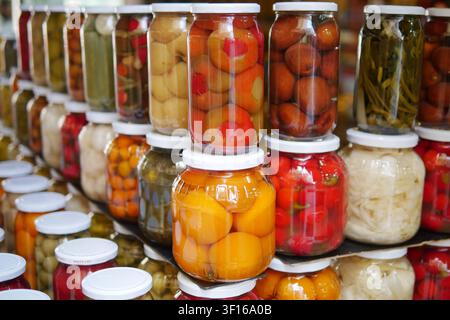 Farbenfrohe Gläser mit konserviertem Obst und Gemüse Stockfoto