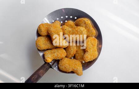 Frittierte HühnerNuggets auf einem Schlitzlöffel, Ansicht von oben Stockfoto