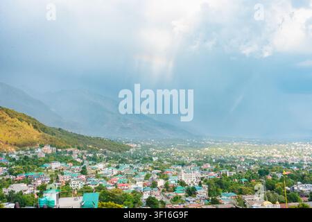 Eine weitwinklige Landschaftsansicht der Stadt Dharamshala, die in den Ausläufern des Himalaya unter einem stürmischen Himmel liegt. Stockfoto