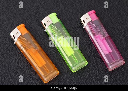 Transparente Plastik-Feuerzeug auf schwarzem Tischhintergrund Stockfoto
