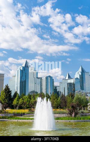 Schöner neuer landschaftlich gestalteter Park mit Wasserbrunnen, umgeben von moderner Architektur in Almaty Kasachstan. Stockfoto
