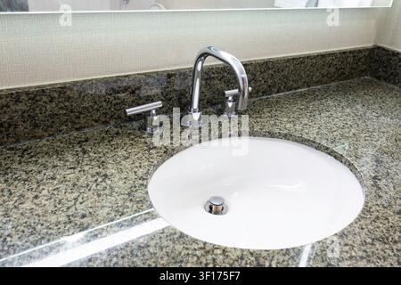 Waschbecken mit Marmorplatte und eingebautem Wasserhahn Stockfoto