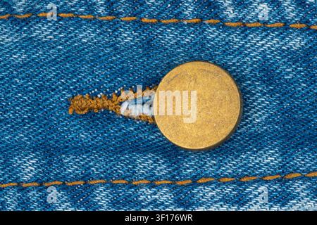 Blauer Denimjeans-Stofftextur mit metallischem Nietenknopf. Detaillierte Makro-Nahaufnahme von Texturnähten und Bekleidungsverschluss. Bequemem Kleidungsmaterial Stockfoto