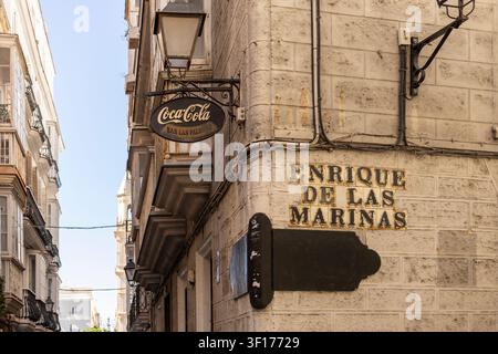 Cadiz, Spanien, 12. September 2025 Vintage spanische Straßenecke mit Enrique De Las Marinas Schild und Coca-Cola Bar Plakette Stockfoto