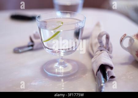 Ein Glas kühles Wasser mit einer Limettenscheibe in einem Restaurant Stockfoto