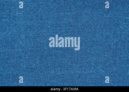 Detaillierte Makroaufnahme von blauem Denimstoff. Klassisches Jeans-Textil zeigt intrigante gewebte Baumwollfäden. Perfekt als neutraler, texturierter Hintergrund für Mode Stockfoto