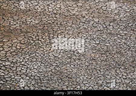Tiefe Risse breiten sich während des Sommerhöchstes über trockenes Land aus und veranschaulichen die schweren Auswirkungen von Dürre und langanhaltendem Wassermangel. Stockfoto