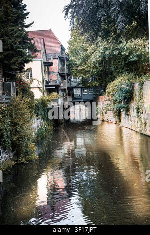 Historischer Kanal, der unter einem überdachten fachwerkgebäude in der Altstadt von Stade, Deutschland, verläuft, mit Spiegelungen auf ruhigem Wasser Stockfoto