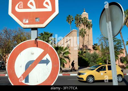 Verkehrsschilder, ein Stoppschild und ein Schild „Keine Rechtsabbiege“, ein Taxi und der Minarettturm der Koutoubia-Moschee, Marrakesch, Marokko, Nordafrika Stockfoto