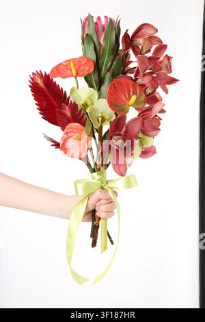 Frau hält einen Strauß tropischer Blumen auf weißem Hintergrund, Nahaufnahme Stockfoto