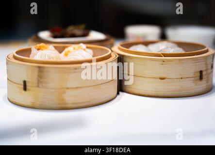 Hong Kong, China – Dampfende Bambuskörbe mit zarten Garnelenknödeln (har gow) und anderem Dim Sum Stockfoto