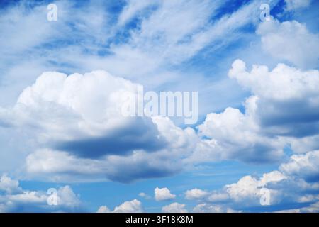 Schöner blauer Himmel mit flauschigen weißen Kumuluswolken und leichten, fadenförmigen Zirruswolken an einem sonnigen Tag. Stockfoto