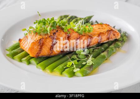 Perfekt gegrillter Lachs serviert mit Spargel und Mikrogrün in gesunder Gourmet-Präsentation Stockfoto
