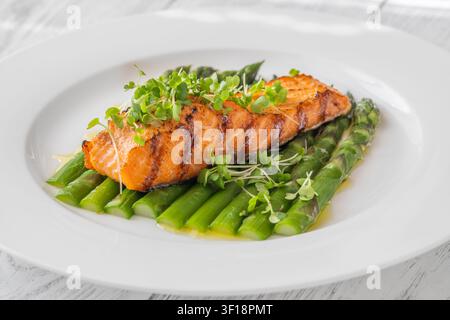 Perfekt gegrillter Lachs serviert mit Spargel und Mikrogrün in gesunder Gourmet-Präsentation Stockfoto