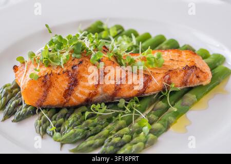 Perfekt gegrillter Lachs serviert mit Spargel und Mikrogrün in gesunder Gourmet-Präsentation Stockfoto