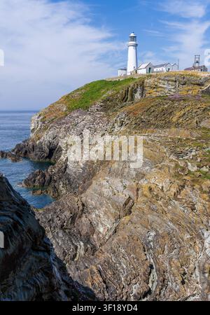 Der historische South-Stack-Leuchtturm erhebt sich über den schroffen Küstenklippen der Holy Island in Anglesey, Nordwales, an einem sonnigen Sommertag. Stockfoto