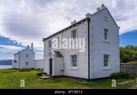 Die historischen Leuchtturmwächterhäuser von 1839 stehen entlang der Schotterstraße in der Nähe von Penmon Point in Anglesey. Stockfoto
