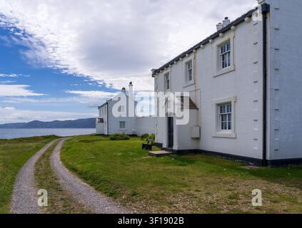 Die historischen Leuchtturmwächterhäuser von 1839 stehen entlang der Schotterstraße in der Nähe von Penmon Point in Anglesey. Stockfoto