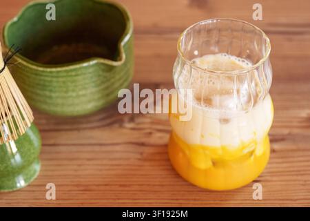 Glas mit Mangopüree und Milch für ein Iced Matcha Latte-Rezept Stockfoto