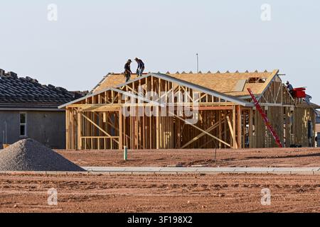Apache Junction, Arizona, USA. 11. Juli 2026. Arbeiter bauen ein Einfamilienhaus in einer Wohnsiedlung in Pinal County, Arizona. Der Bau von Einfamilienhäusern in den USA ist kürzlich auf einen Achtmonatstief gefallen, da hohe Hypothekenzinsen und gestiegene Baukosten weiterhin die neue Wohnungsbauaktivität belasten. Trotz des nationalen Rückgangs geht die Wohnsiedlungsentwicklung in Zentralarizona weiter, während Bauunternehmer daran arbeiten, das langfristige Bevölkerungswachstum und den Wohnungsbedarf zu decken. (Bildnachweis: © Eduardo Barraza/ZUMA Press Wire) NUR FÜR REDAKTIONELLE NUTZUNG! NICHT FÜR KOMMERZIELLE NUTZUNG! Stockfoto