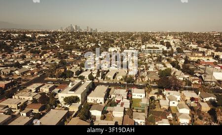 Luftaufnahme einer Stadtlandschaft mit Wohndächern und einer fernen Skyline unter einem dunstigen Nachmittaghimmel, Los Angeles, Kalifornien Stockfoto