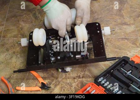 Technischer Ingenieur repariert und misst das elektronische Motherboard eines elektrischen Massagestuhls mit professionellen Werkzeugen, Hardware-Reparaturdienst. Stockfoto