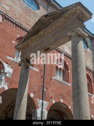 Mailand Italien Juni 24, 2026: Ein suggestiver Blick auf die Piazza dei Mercanti in Mailand, eingerahmt von den historischen Steinbögen des Palazzo della Ragione Stockfoto