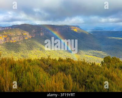 Fotografie eines farbenfrohen Regenbogens über dem Narrow Neck Plateau im Megalong Valley, gesehen vom Cahills Lookout nahe der Stadt Katoomba im Blue Mount Stockfoto