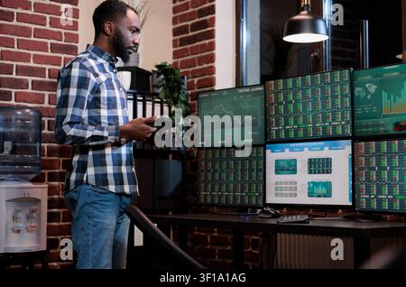 Hedgefonds-Handelsagent verwendet ein Tablet-Gerät, um Kauf- und Verkaufspreisspannen für Investitionsentscheidungen zu analysieren, unterstützt die Marktanalyse und Investitionsentscheidungen. Stockfoto