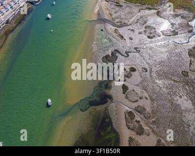 Luftaufnahme des Küstenkanals und der Sandbänke von Cabanas mit kleinen Booten, die im türkisfarbenen Wasser vor Anker liegen, und der Marschlandschaft in Cabanas, Faro, P Stockfoto