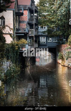 Historischer Kanal, der unter einem überdachten Fachwerkgebäude in der Altstadt von Stade, Deutschland, verläuft, malerische Uferlandschaft Stockfoto
