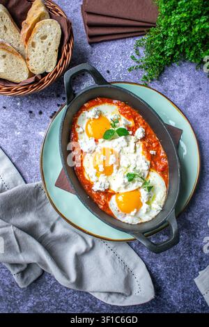 Shakshuka mit gebackenen Eiern in reichhaltiger Tomatensauce, serviert in einer Gusseisenpfanne Stockfoto
