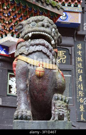 Chinesischer Wächter-Foo-Hund-Löwe (weiblich) mit der Pfote auf einem Jungtier vor dem Jianfu-Tempel auf dem Qingcheng-Berg in Dujiangyan, Chengdu, Provinz Sichuan, China Stockfoto