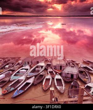 Viele alte Holzboote zusammen auf dem Ganges in Varanasi im schönen Sonnenlicht des Abends Stockfoto