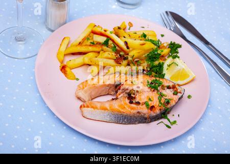 Gebackenes Lachssteak mit Pommes frites Stockfoto