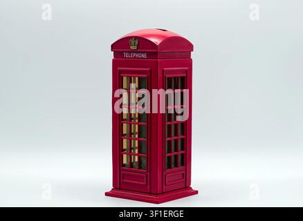 Rote Miniatur-Londoner Telefonzelle-Sparbüchse isoliert auf einem sauberen weißen Hintergrund für Ersparnisse. Stockfoto