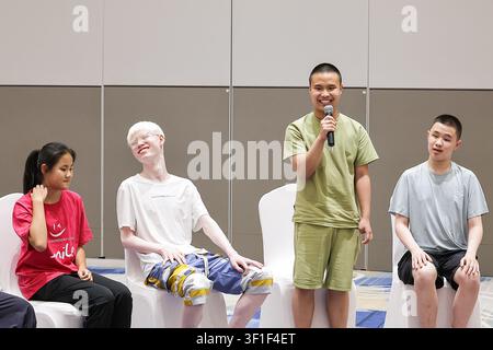 Peking, China. 12. Juli 2026. Ein Junge spricht während eines Sommercamp-Events in Peking, der Hauptstadt Chinas, am 12. Juli 2026. UNICEF China? lud am Sonntag die Weltmeisterschafts-Goldmedaillengewinnerin im Tauchen Chen Yuxi zu einem Sommercamp-Event ein, an dem Kinder mit Sehbehinderungen teilnahmen, um Kindern mit Behinderungen zu helfen, ihr Potenzial zu entdecken, und das öffentliche Bewusstsein für den Schutz ihrer Rechte zu schärfen. Credit: Zhang Yuwei/Xinhua/Alamy Live News Stockfoto
