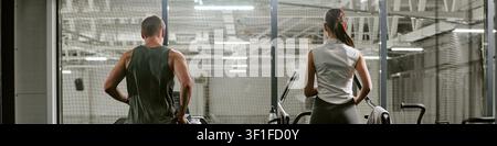 Überschrift von Mann und Frau, die im Fitnessstudio auf Laufbändern trainieren Stockfoto