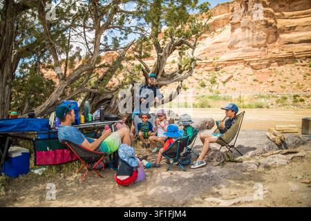 Familie und Freunde entspannen an einem Flussufer-Campingplatz Stockfoto