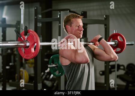 Mann führt Front Rack Barbell Lift im Fitnessstudio für Fitness durch Stockfoto