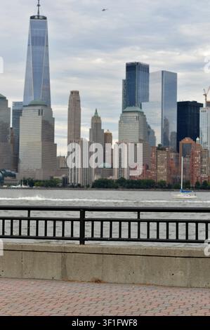 Promenade-Zaun in vertikaler Rahmenzeichnung, Blick auf die Wolkenkratzer von Manhattan, stimmungsvolle Wolken, New York Stockfoto