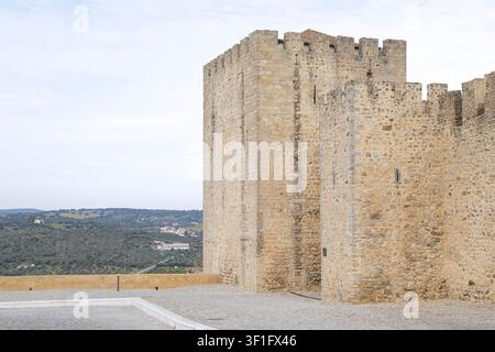 Die steinernen Verteidigungsmauern und der historische Turm der Burg von Elvas mit Blick auf die ländliche Landschaft und die sanften Hügel der Region Alentejo, in Elvas, Portugal Stockfoto