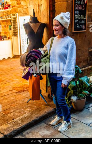 Frau beim Einkaufen auf der Straße, die Taschen und Kleidung hält Stockfoto