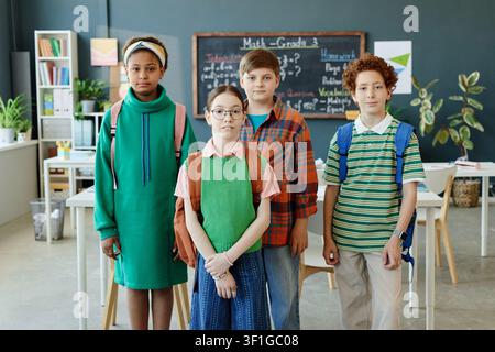 Porträt von vielfältigen Schulkindern, die im Klassenzimmer für Bildung stehen Stockfoto