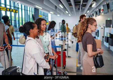 Verschiedene Reisende stehen am Flughafen am Check-in-Schalter Schlange Stockfoto