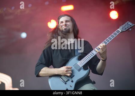 25. Juni 2025 - Sofia, Bulgarien: KHANЪ-Gitarrist Dimitar Proynov spielt E-Gitarre unter rotem Bühnenlicht während des Vorprogramms der Band für The HU Stockfoto