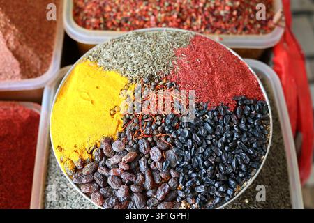 Buntes Sortiment aus gemahlenen Gewürzen, getrockneten Kräutern, Zimtstangen, Pfefferkörnern und Gewürzen, präsentiert auf einem traditionellen Bauernmarkt in Usbekistan Stockfoto